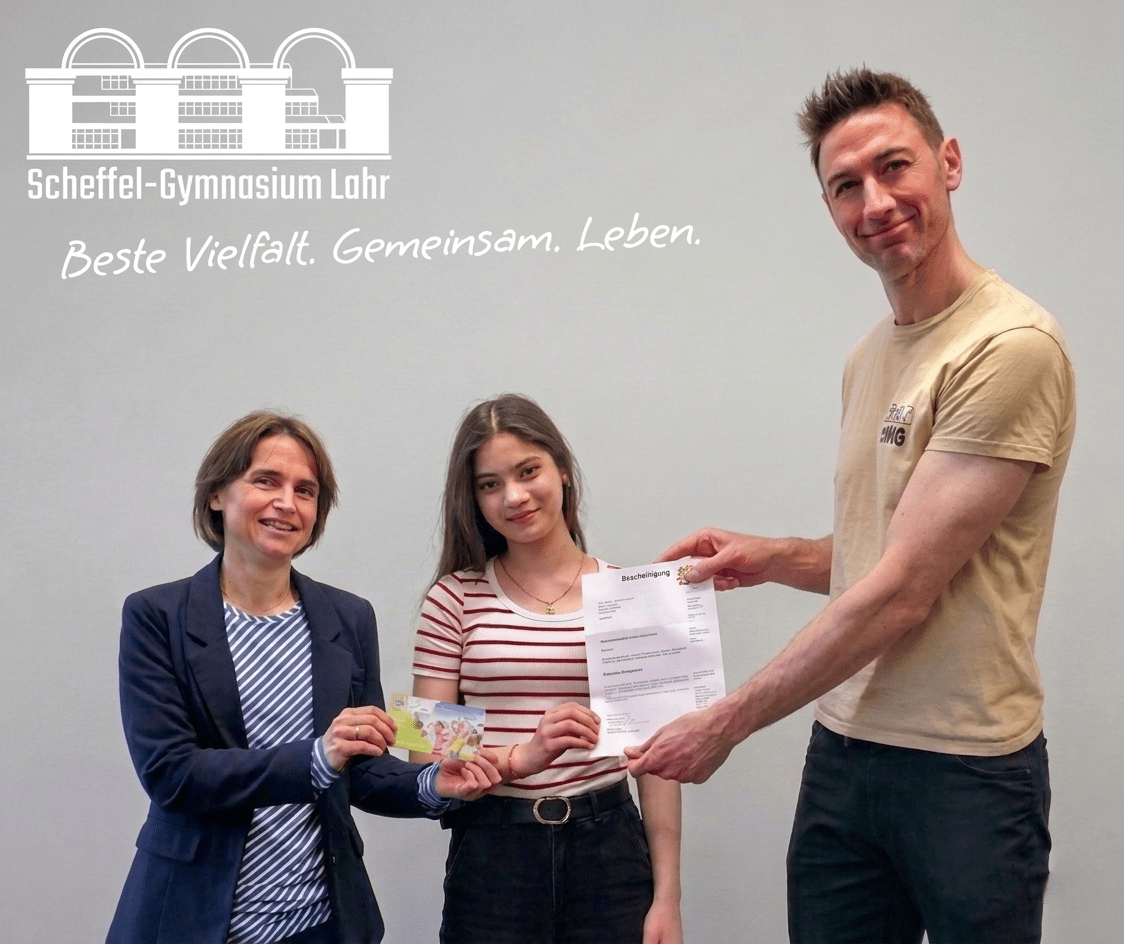 Die Scheffel Schülerin Eylül Oktay erhält von Deutschlehrerin Bettina Hölscher und stellvertretendem Schulleiter Philipp Freykowski die Urkunde und den Preis für ihren 3. Platz beim Zischup Wettbewerb.