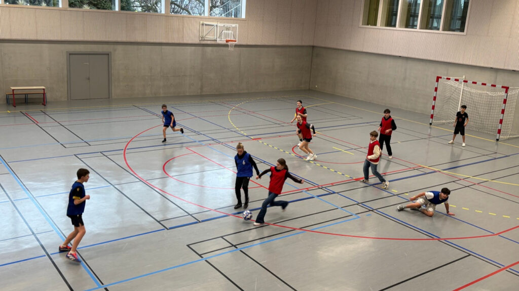 Die Schüler spielen in einer Halle Fußball
