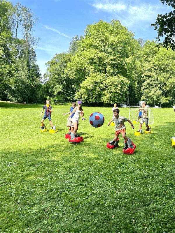 Bild 2 Lahr in Dole Schülerinnen und Schüler spielen Fußball mit Riesenschuhen an den Füßen in einem Park